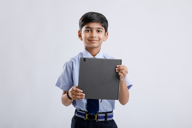 Cute little Indian / Asian school boy showing note book