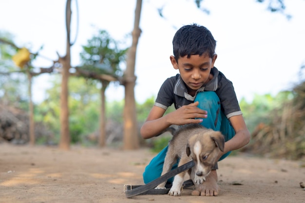 Cute little Indian boy playing with dog puppy