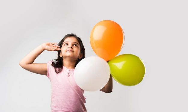 Cute little indian girl with tri colour balloons - Saluting national Flag and celebrating Independence or Republic day of India