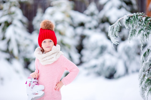 Cute little kid girl is going skate outdoors.