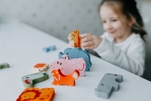 Photo cute little kid playing with toy animals like giraffe and koala