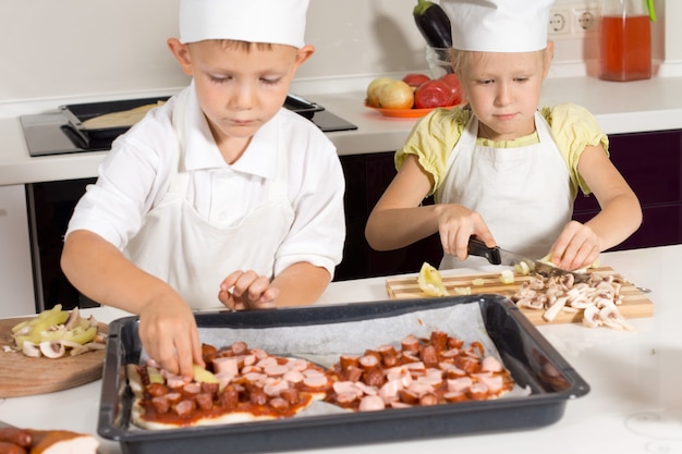 Cute Little Kids in Chef Attire Making Tasty Pizza in the Kitchen.