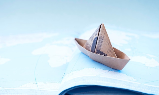 Cute little paper boat on the world map