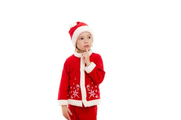 Милый маленький задумчивый мальчик в красном костюме Санта-Клауса