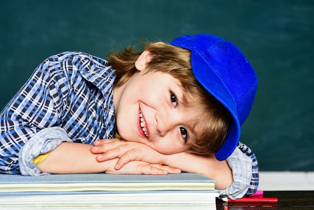 Cute little preschool kid boy in a classroom. schoolchild.
happy mood smiling broadly in school