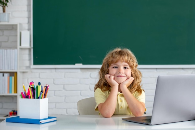 Cute little school kid boy study in a classroom online learning technology