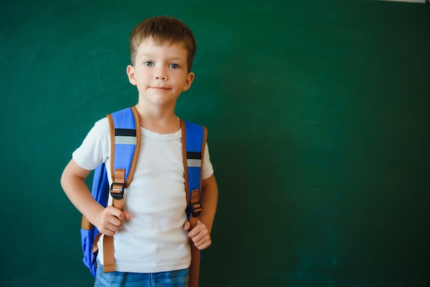 Foto piccolo scolaro sveglio che si siede nell'aula