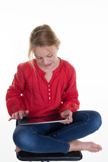 Cute little smiling girl using tablet computer