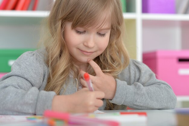 Cute little student girl at art class at school