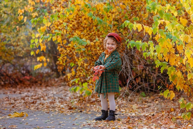 Cute little stylish girl in the autumn park