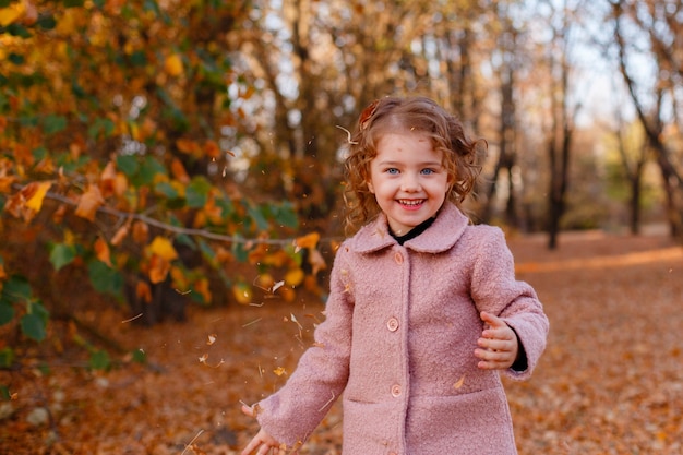 Милая маленькая стильная девочка в осеннем парке