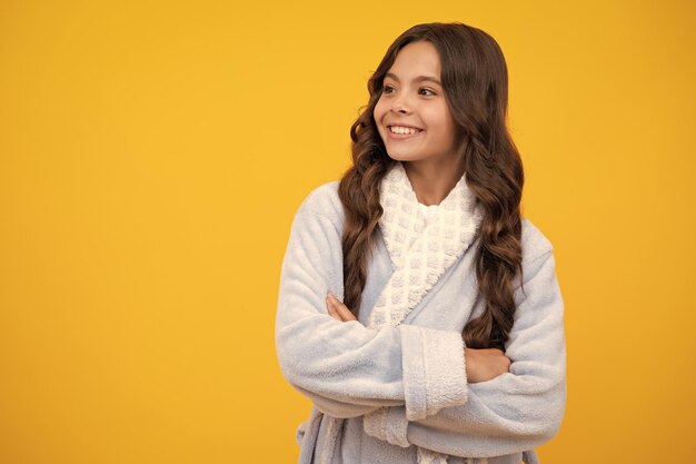 Cute little teenager girl crossing arms over yellow background copy space