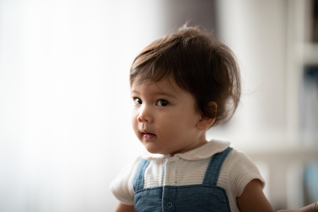 Cute little toddler holding toy while sitting on floor with stuff toy playing with father at home