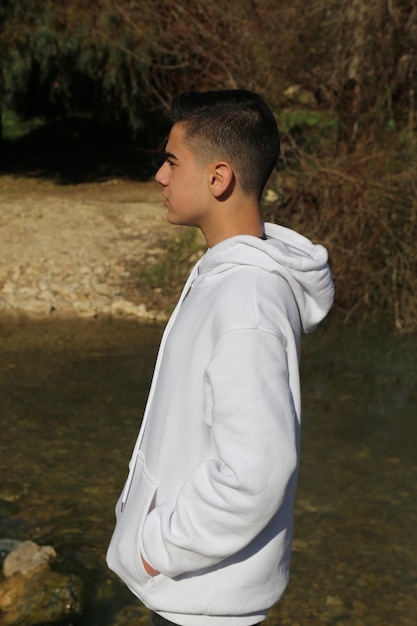 Foto un ragazzino carino che cammina nel parco forestale all'aperto