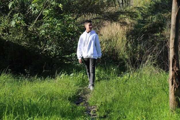 A cute little young boy walking in the outdoor forest park