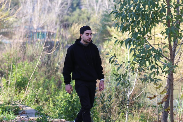 A cute little young boy walking in the outdoor forest park