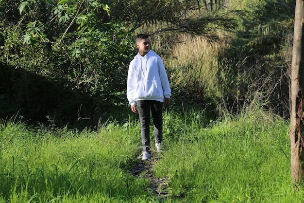 A cute little young boy walking in the outdoor forest park