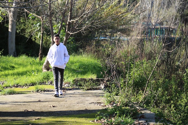 Photo a cute little young boy walking in the outdoor forest park