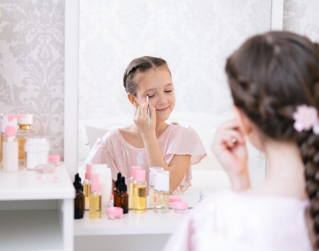 Photo cute little young lady doing make up in a bedroom light and airy portrait