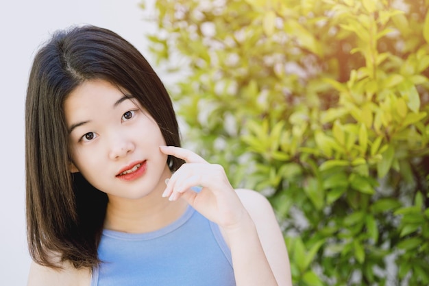 Cute lovely portrait asian Thai teen smile with green nature copy space