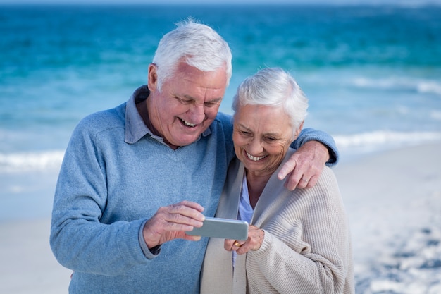 Cute mature couple looking at smartphone