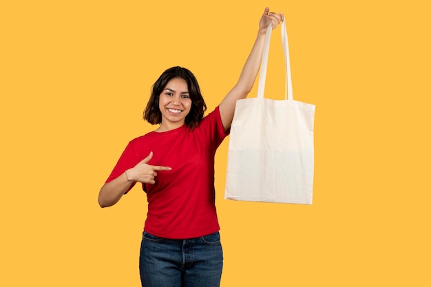 Cute middle eastern lady pointing at shopper