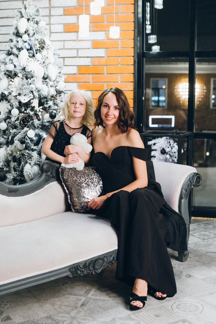 Photo cute mom and little blonde daughter posing at the christmas tree