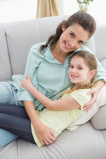 Симпатичная мать и дочь на диване