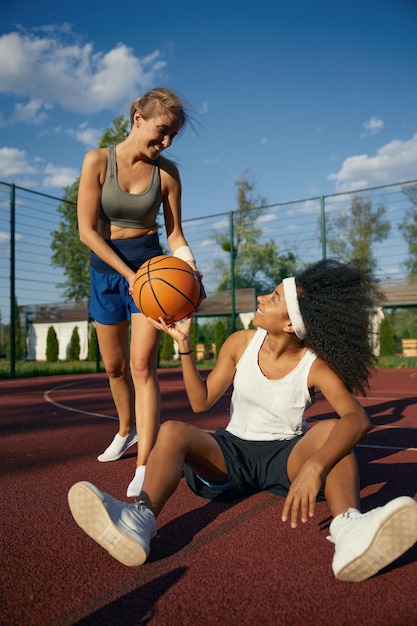 Cute multicultural female basketball player taking rest