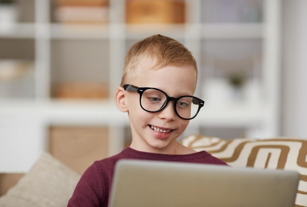 Cute nerd boy using laptop