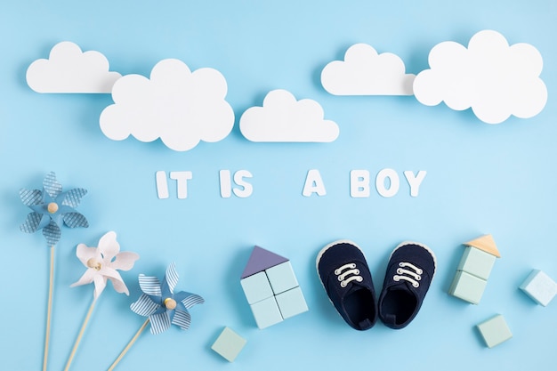 Photo cute newborn baby boy shoes with festive decoration over blue wall.