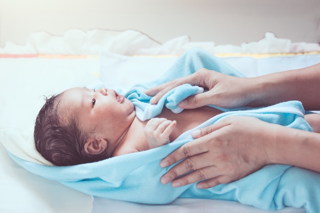 Cute newborn baby girl in towel after bath