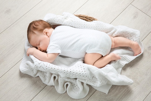 Cute newborn baby sleeping in basket at home