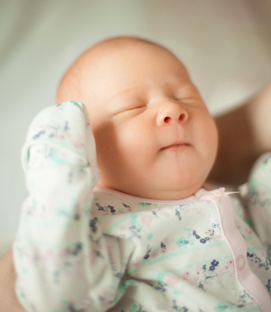 Cute newborn baby sleeps in the arms of his mother