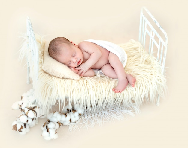 Cute newborn lying on child bed