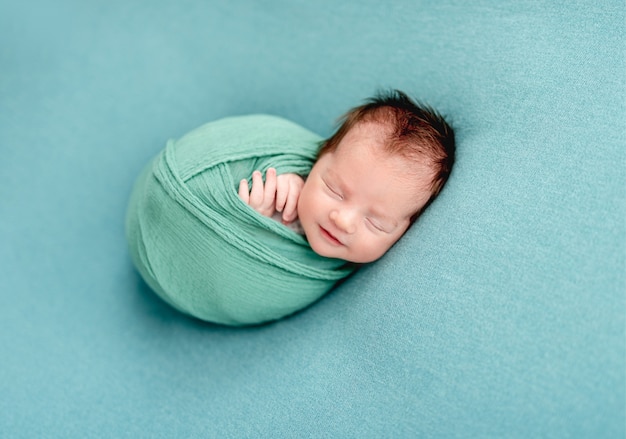 毛布に包まれたかわいい新生児