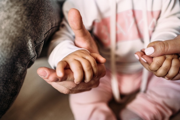 子供の小さな女の子と彼女の両親のクローズアップ家族の手のかわいい写真は、高品質の写真をサポートしています