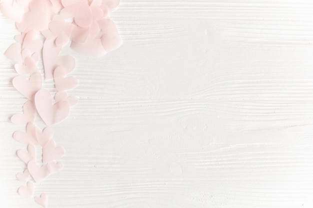 Foto simpatici cuori rosa pastello su fondo di legno bianco con spazio per il testo disposizione piatta buon san valentino ritagli di cuore di carta rosa su biglietto di auguri immagine delicata bianca