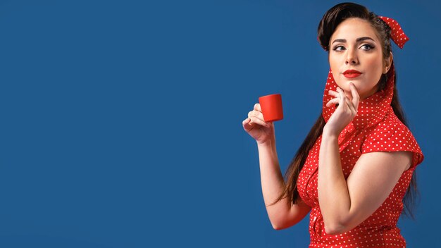 Cute pinup girl posing in a blue studio