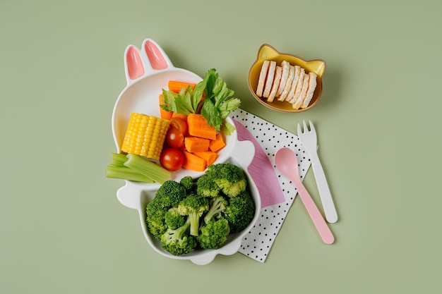 新鮮な野菜とうさぎの形をしたかわいいプレート。子供のための食品のアイデア。にんじんとブロッコリーを使った子供の健康食品