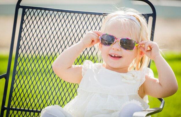 Cute Playful Baby Girl Wearing Sunglasses Outside at the Park