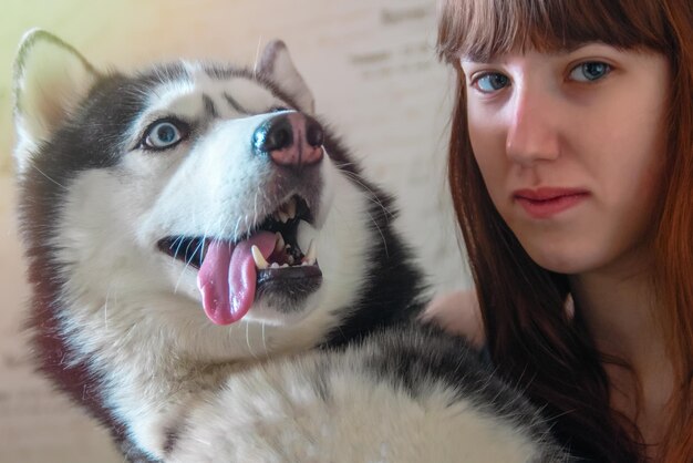 Cute portrait of a girl with a cheerful husky dog