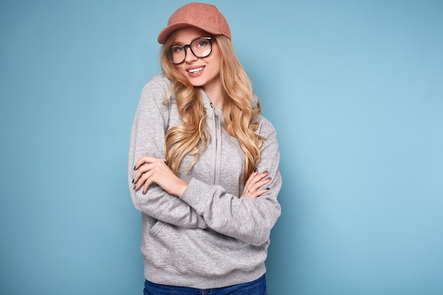 Cute positive blonde woman in a pink baseball cap