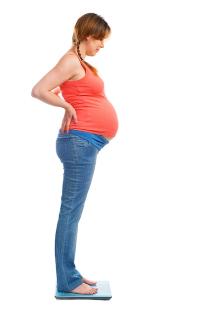 A cute pregnant woman standing on scale