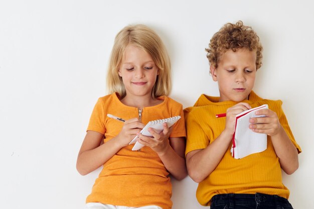 Foto bambini in età prescolare svegli che disegnano giochi divertenti con sfondo isolato blocco note inalterato