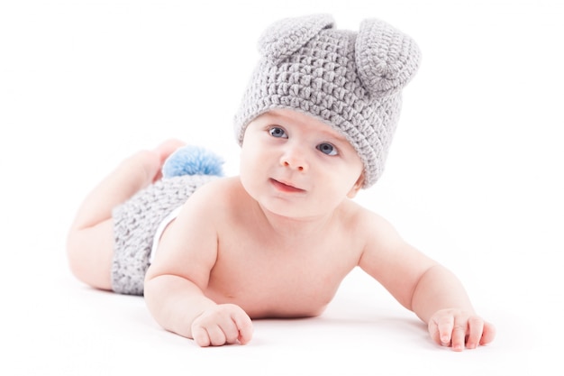 Photo cute pretty baby boy in hair costume lies on tummy