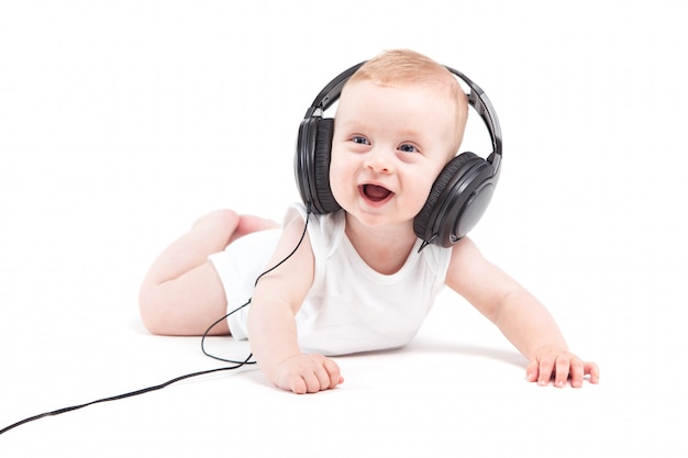 Cute pretty baby boy in white shirt and headphones on head 