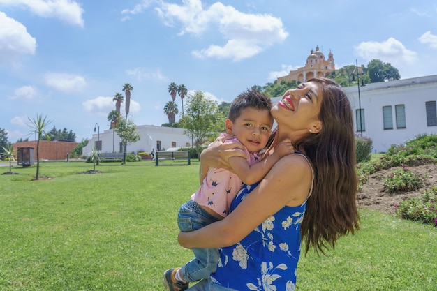 A cute pretty Hispanic boy hugging her mother