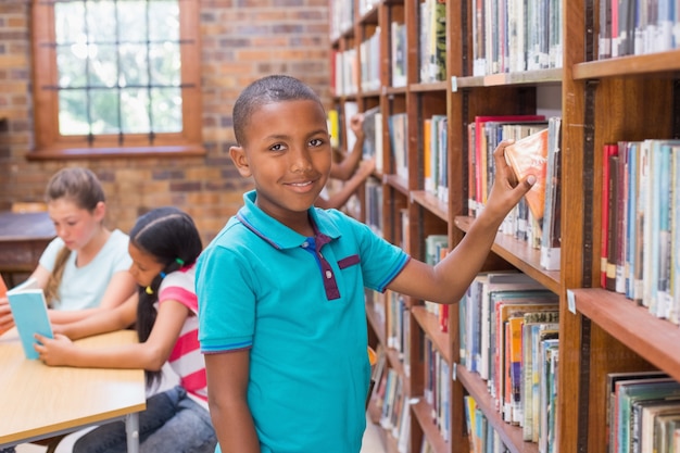 Cute pupil looking for books in library 