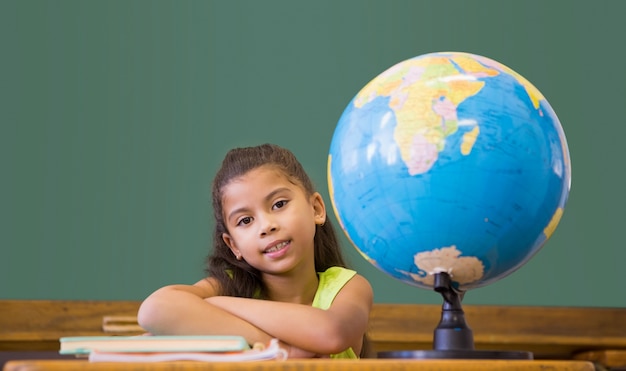 Cute pupil smiling at camera in classroom 